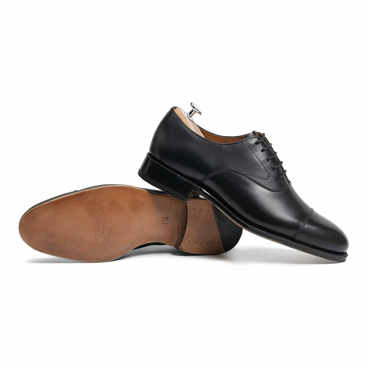 Meermin black boxcalf cap-toe Oxfords, one shoe upright with shoe tree, the other on its side showing leather sole and heel
