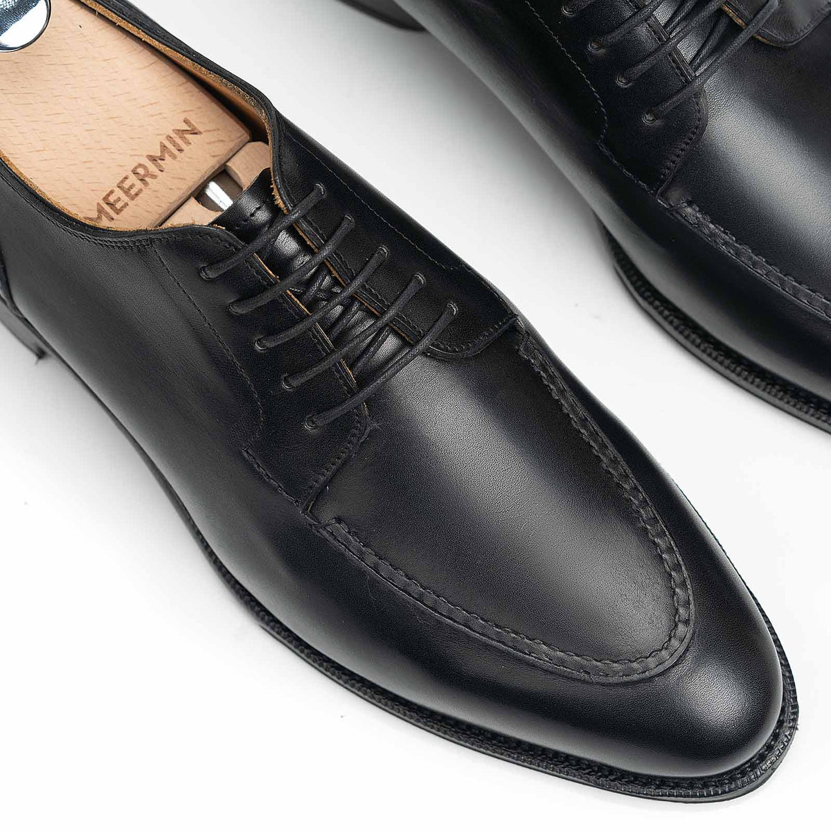 Meermin black boxcalf Norwegian derby, close-up on lace-up vamp and apron stitching with wooden shoe tree inserted