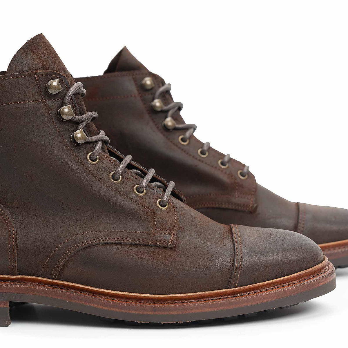 Meermin waxy commander boots in rust suede, close-up on cap-toe, lacing hardware and stitching detail with sole edge visible