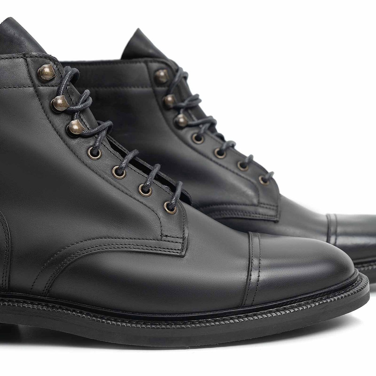 Meermin black waxy calf cap-toe boots, close-up on toe caps and lace eyelets showing stitching detail and leather laces