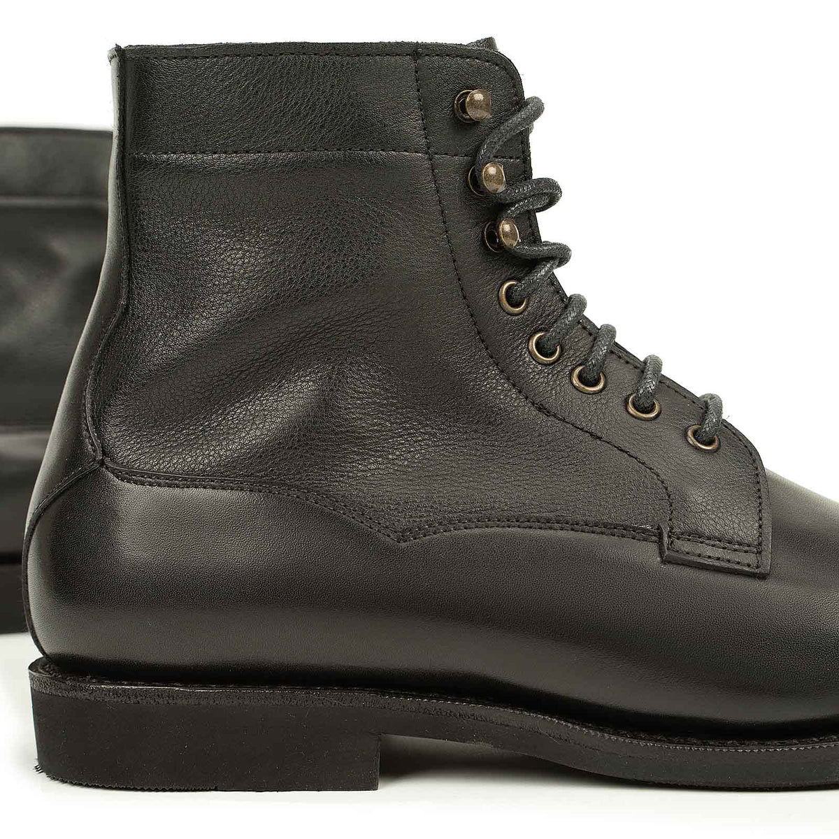 Meermin black boxcalf boot, close-up of lace eyelets and softcalf shaft, showing stitching detail and rubber sole